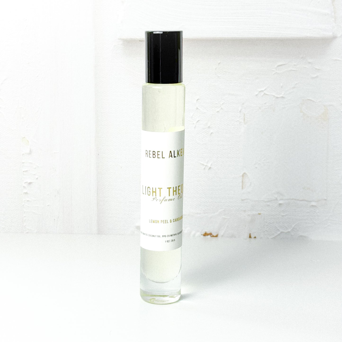 Light Theory perfume oil smells like lemon and cardamom on a white background