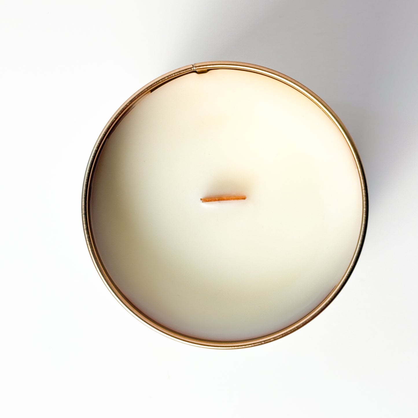 Round candle with a copper rim on a white background