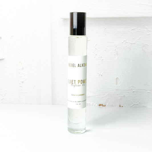 Quiet power perfume oil smells like lavender and cedar on a white background