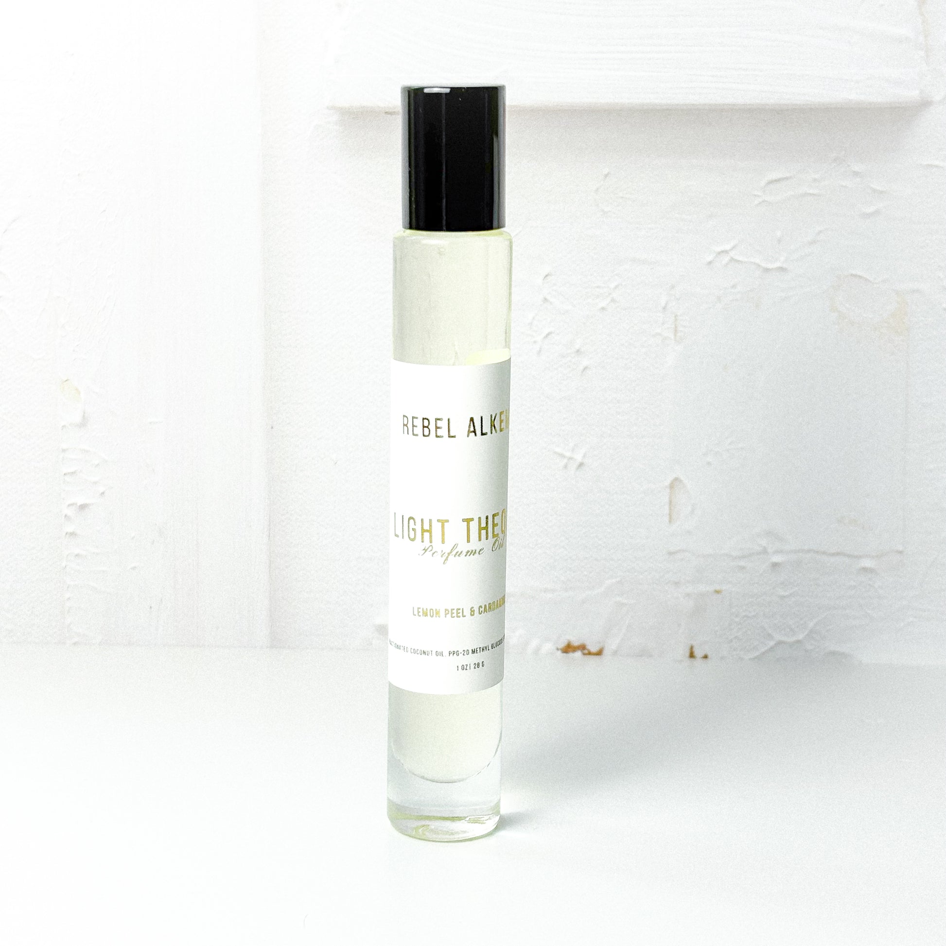 Light Theory perfume oil smells like lemon and cardamom on a white background 