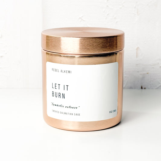 Let it Burn Candle jar with a copper lid and label on a white background
