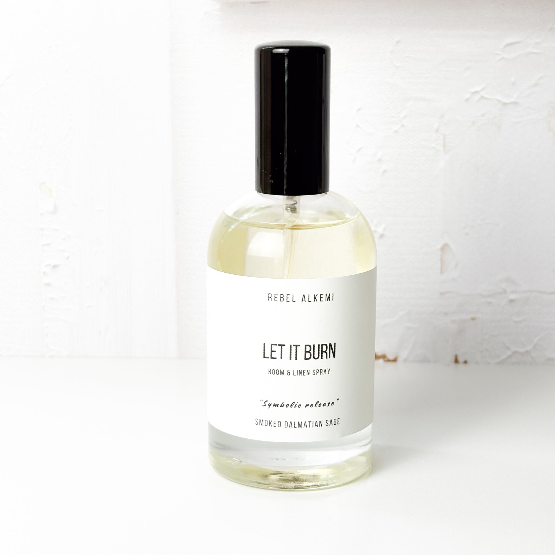 Bottle of Rebel Alkemi 'Let It Burn' room and linen spray on a white background