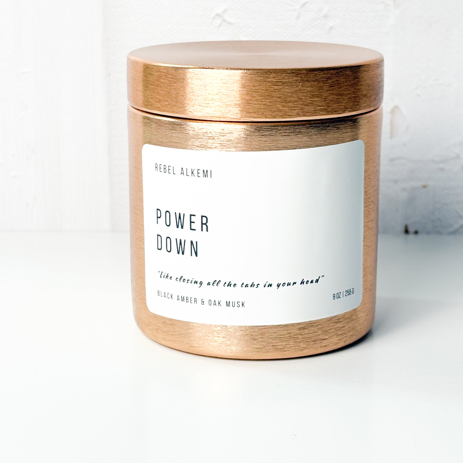 Rebel Alkemi Power Down Candle jar with copper lid and label on a white background