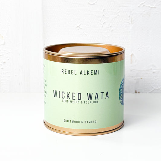 Candle in a green tin with copper lid labeled 'Wicked Wata' by Rebel Alkemi on a white background.
