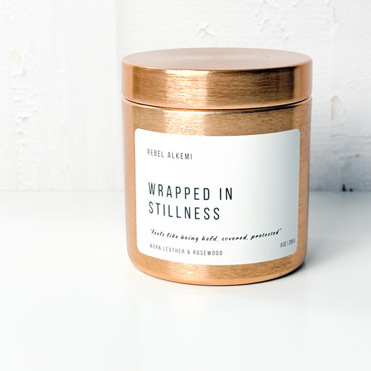 Wrapped in Stillness Candle in a copper container with a white label on a light background