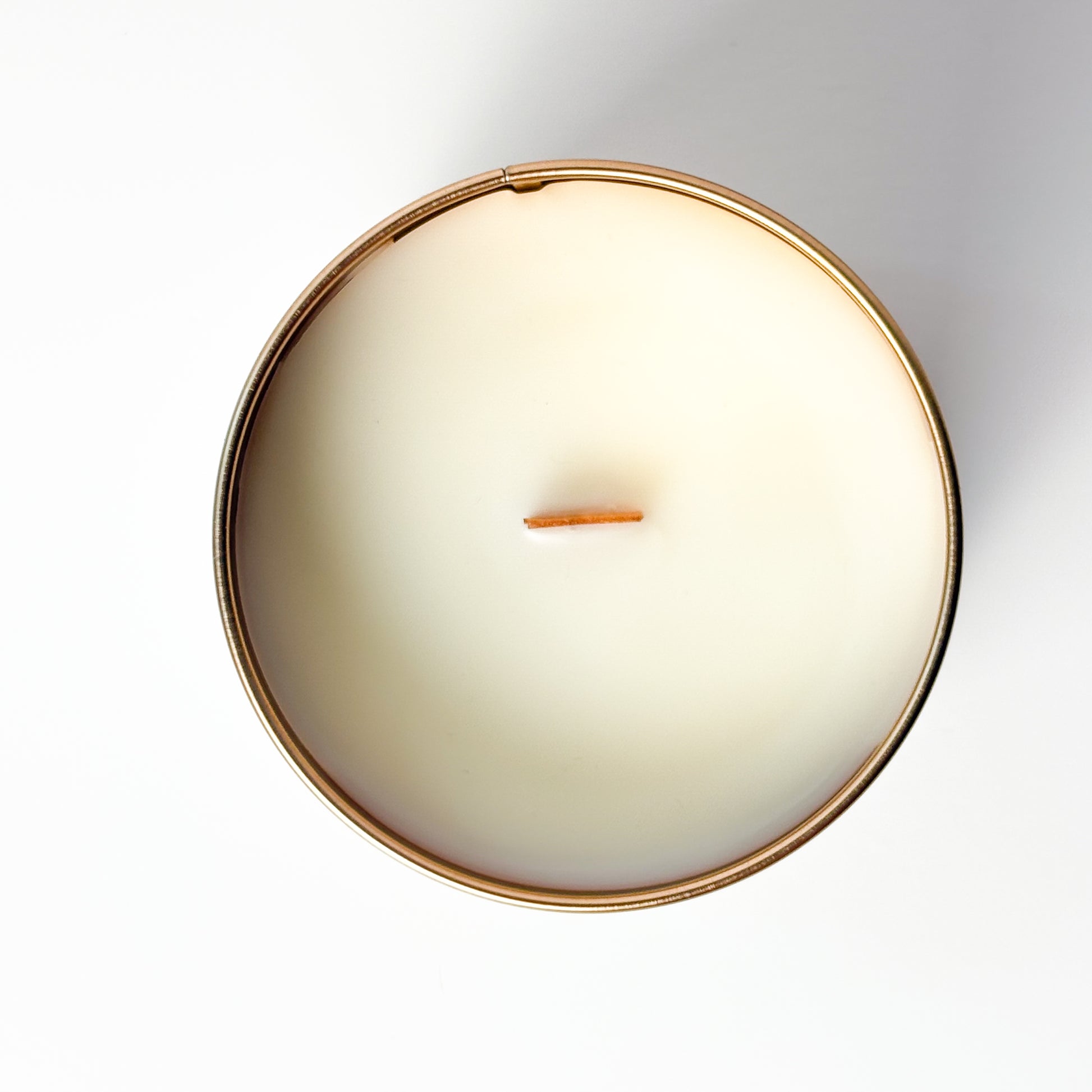 Round candle with a copper rim on a white background